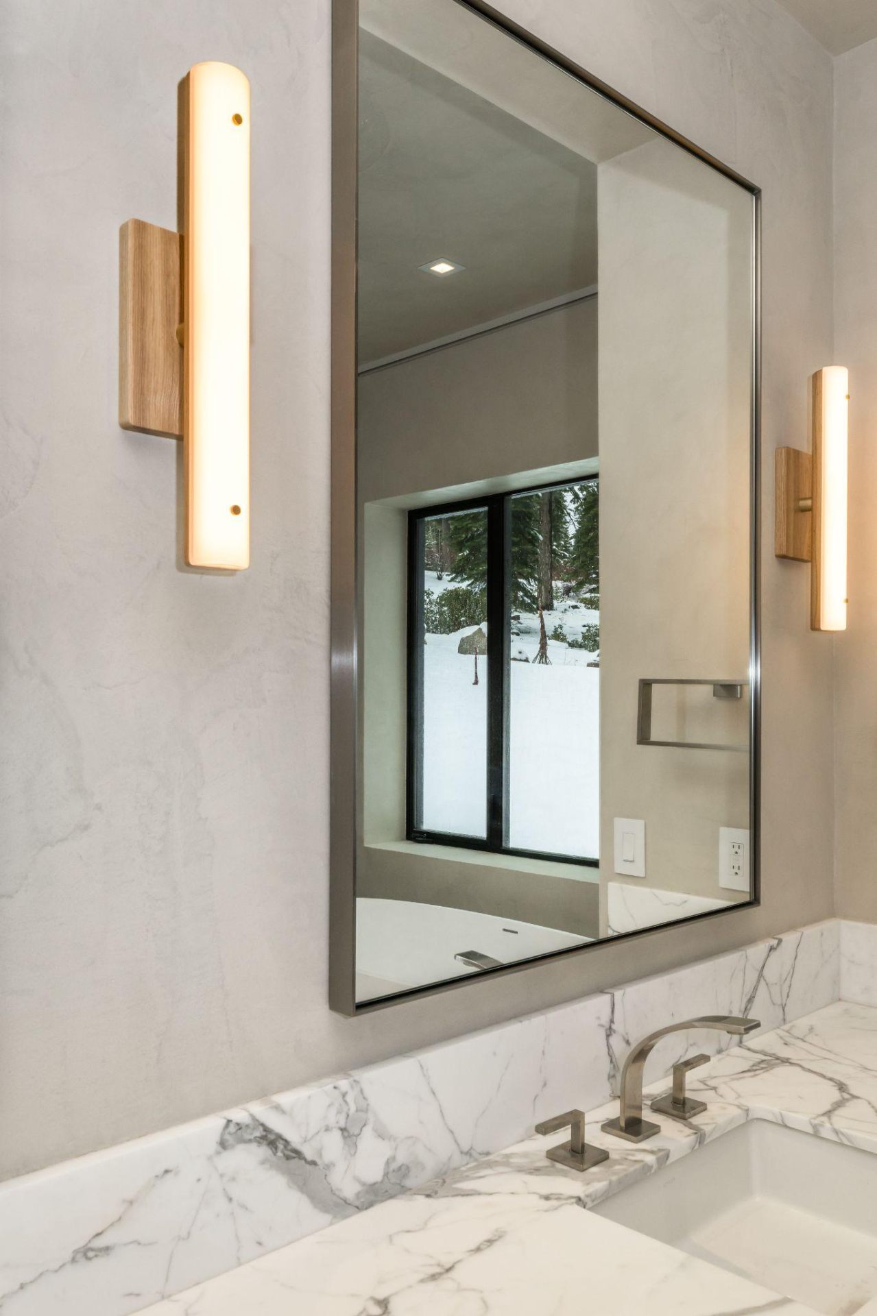 A plaster bathroom wall with a marble counter